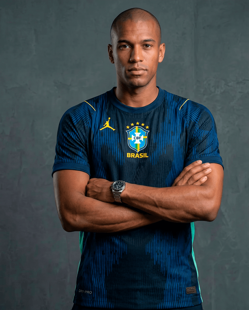 Modelo veste a camisa Brasil Alpha — pose frontal com braços cruzados, escudo CBF e número 10